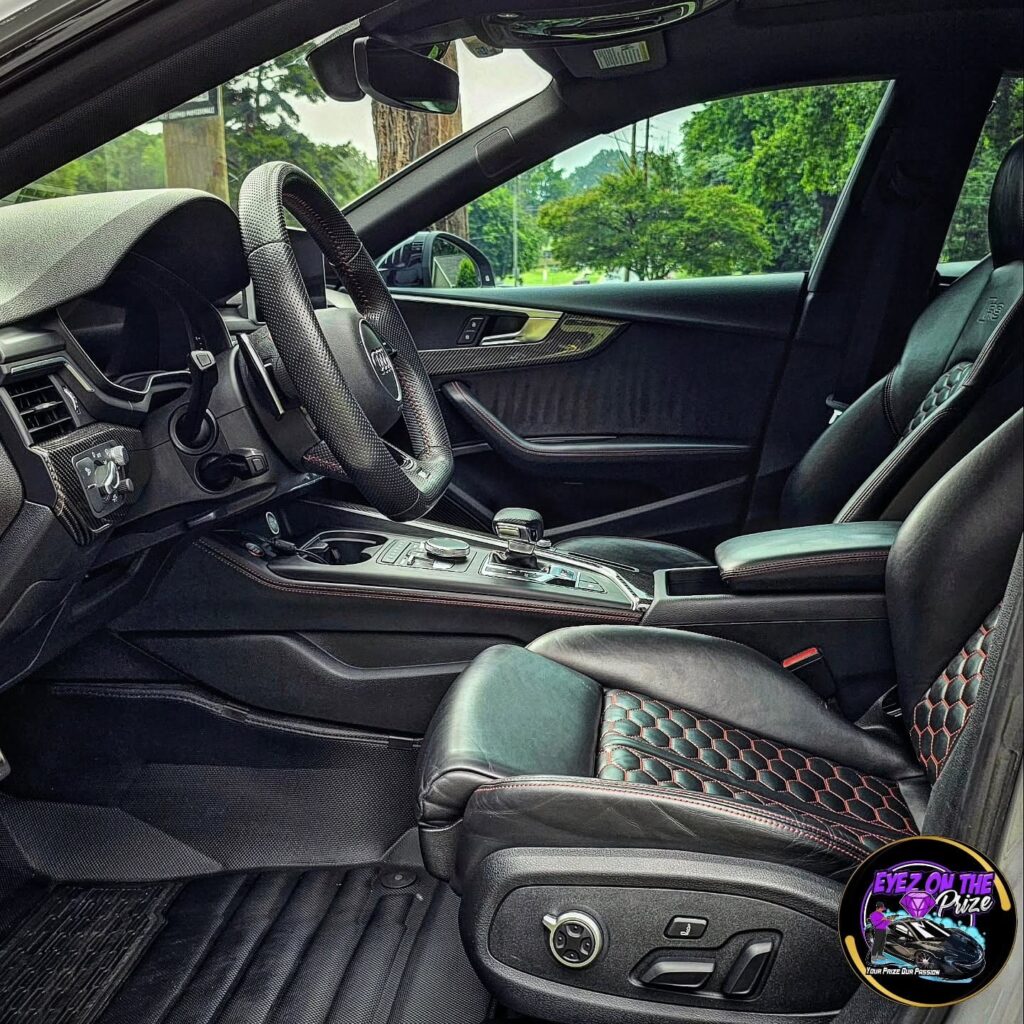 Audi RS5 driver seat and cockpit with black honeycomb leather, red stitching, and carbon fiber trim after interior detailing