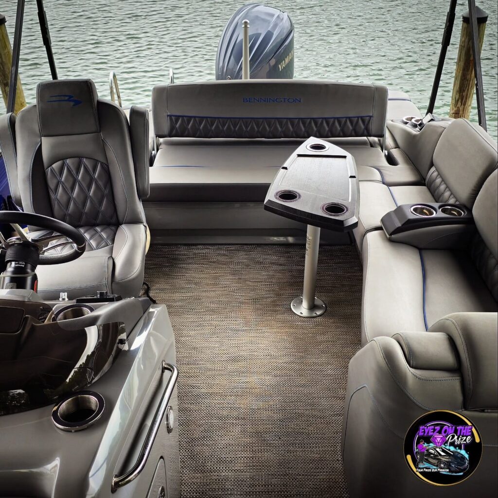 Cleaned Bennington pontoon interior showing gray upholstery, rear bench, table with cup holders, and a Yamaha outboard motor.