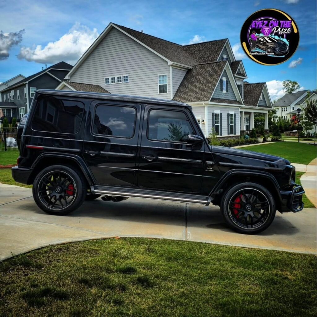 Black Mercedes-AMG G63 SUV with glossy paint parked in a residential driveway after detailing in Charlotte, NC.