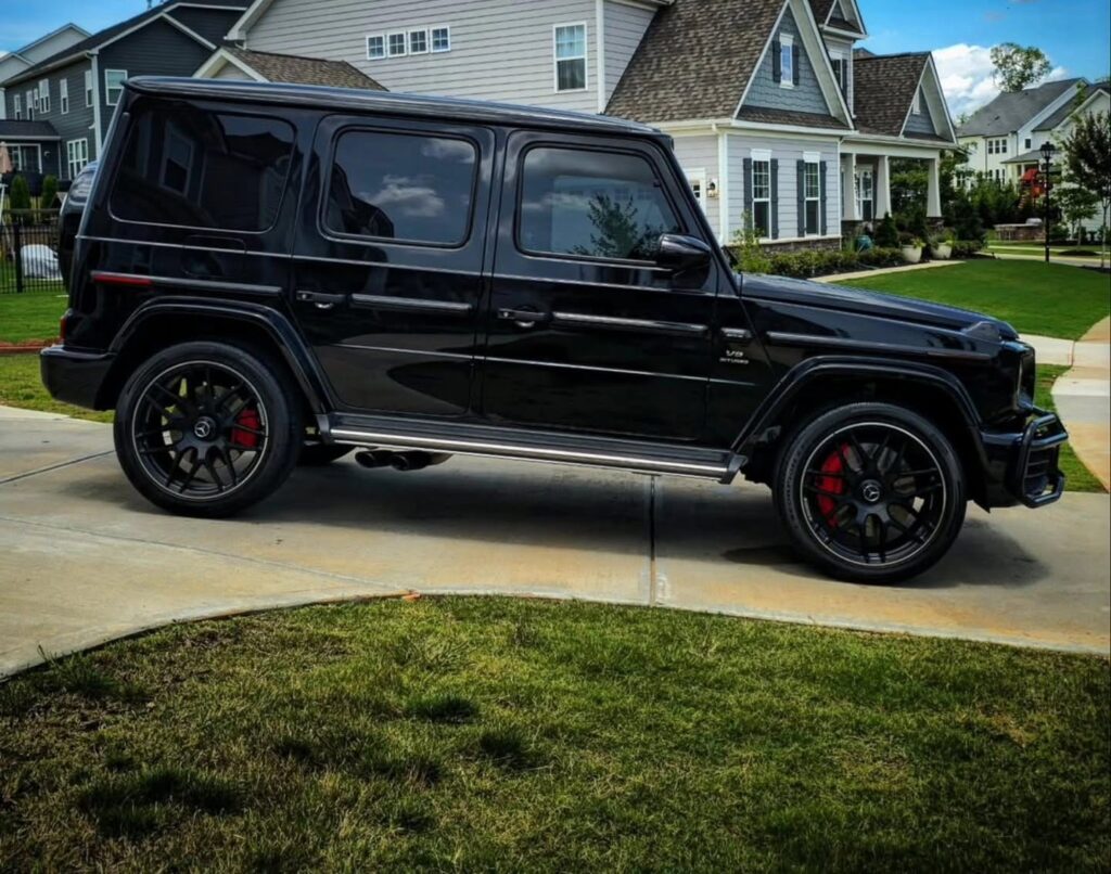 Black Mercedes-AMG G63 SUV with glossy paint parked in a residential driveway after detailing in Charlotte, NC.
