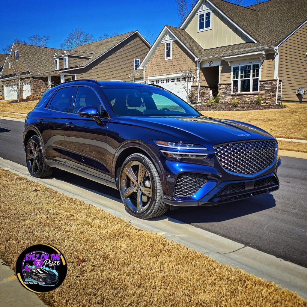 Dark blue Genesis GV70 SUV parked on a residential street after exterior detailing, Charlotte NC.