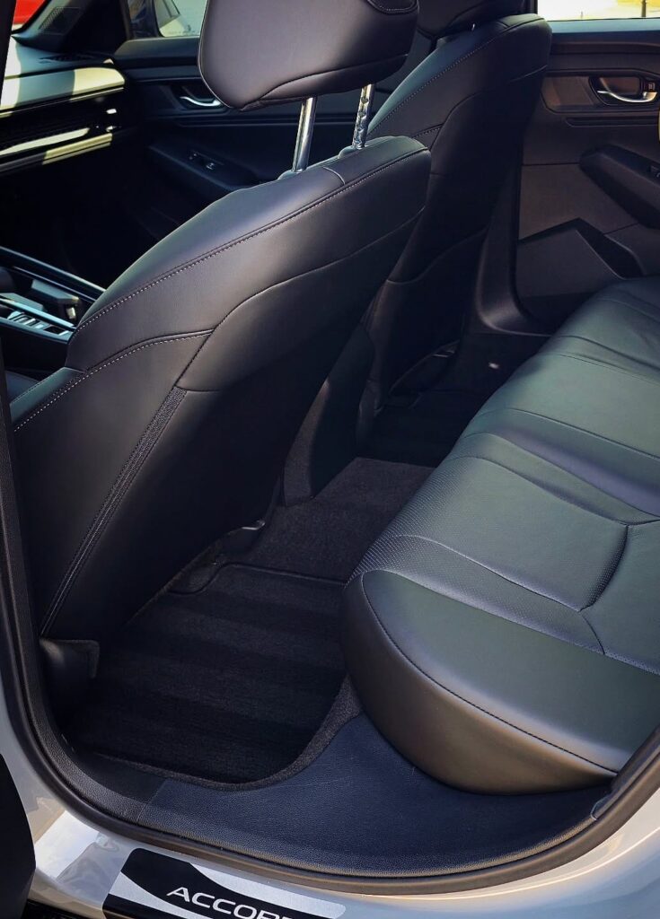 Clean black leather rear seat and vacuumed carpet inside a Honda Accord after interior detailing