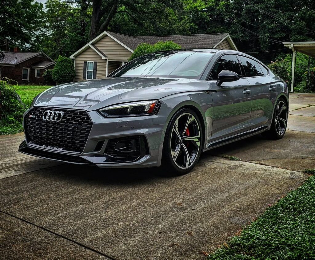 Gray Audi RS5 Sportback parked in a residential driveway after exterior detailing, front three-quarter view