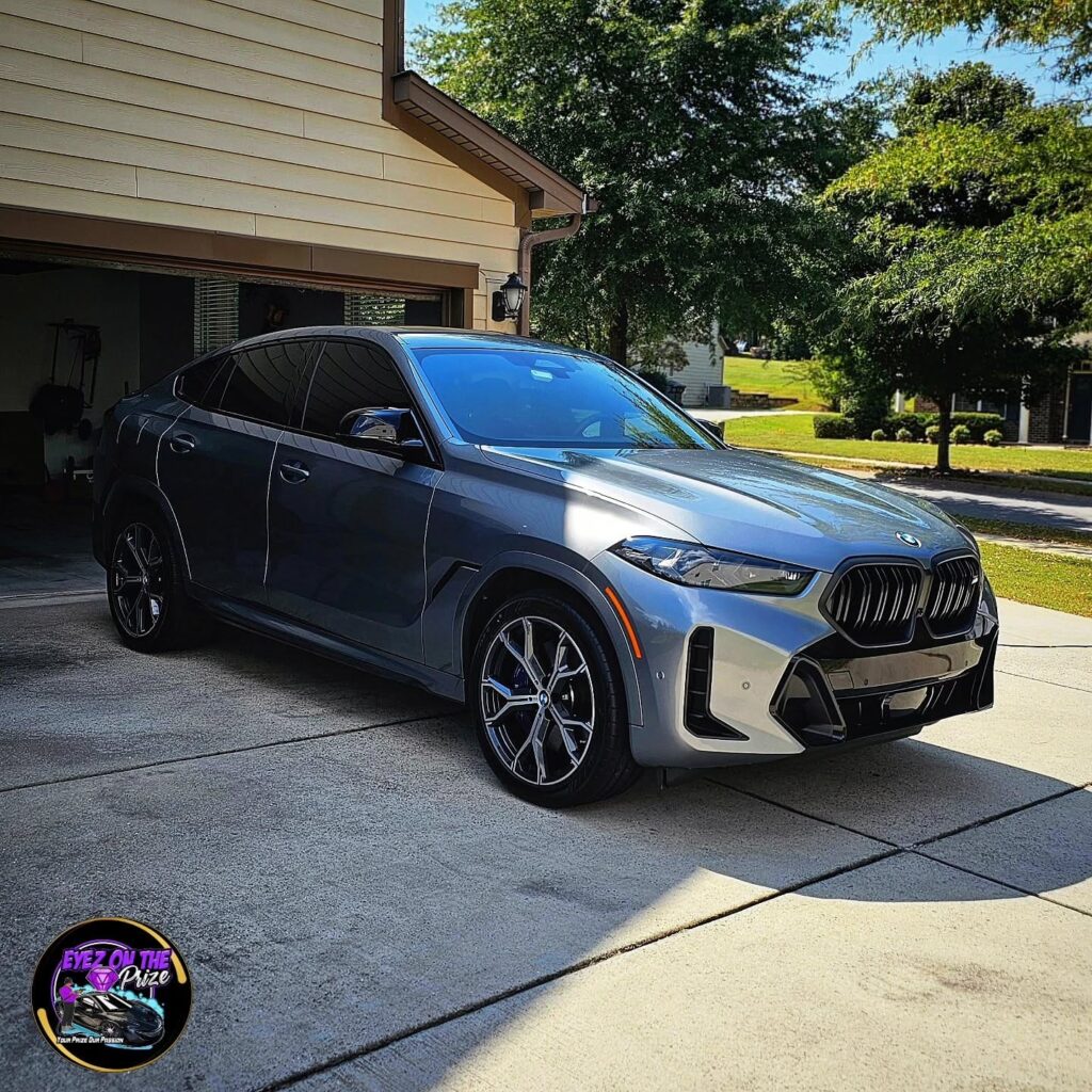 Gray BMW X6 M parked in a residential driveway with glossy paint after professional detailing in Charlotte, NC.