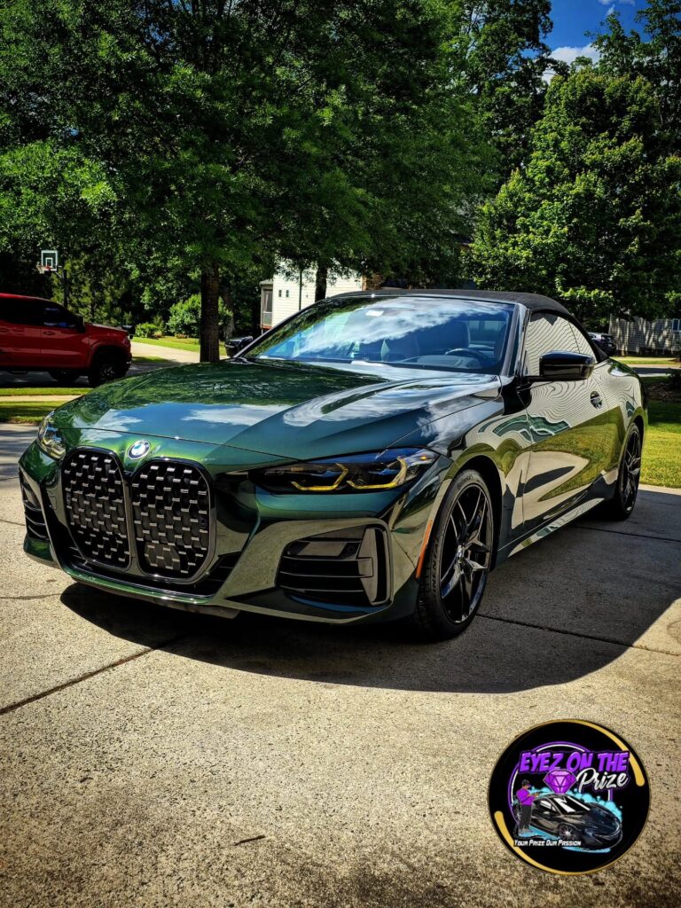 Dark green BMW 4 Series convertible with glossy paint parked on a residential driveway after detailing in Charlotte, NC