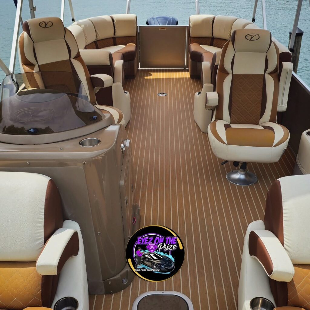 Pontoon boat interior with clean tan and cream upholstered seats and teak-style vinyl flooring at a dock