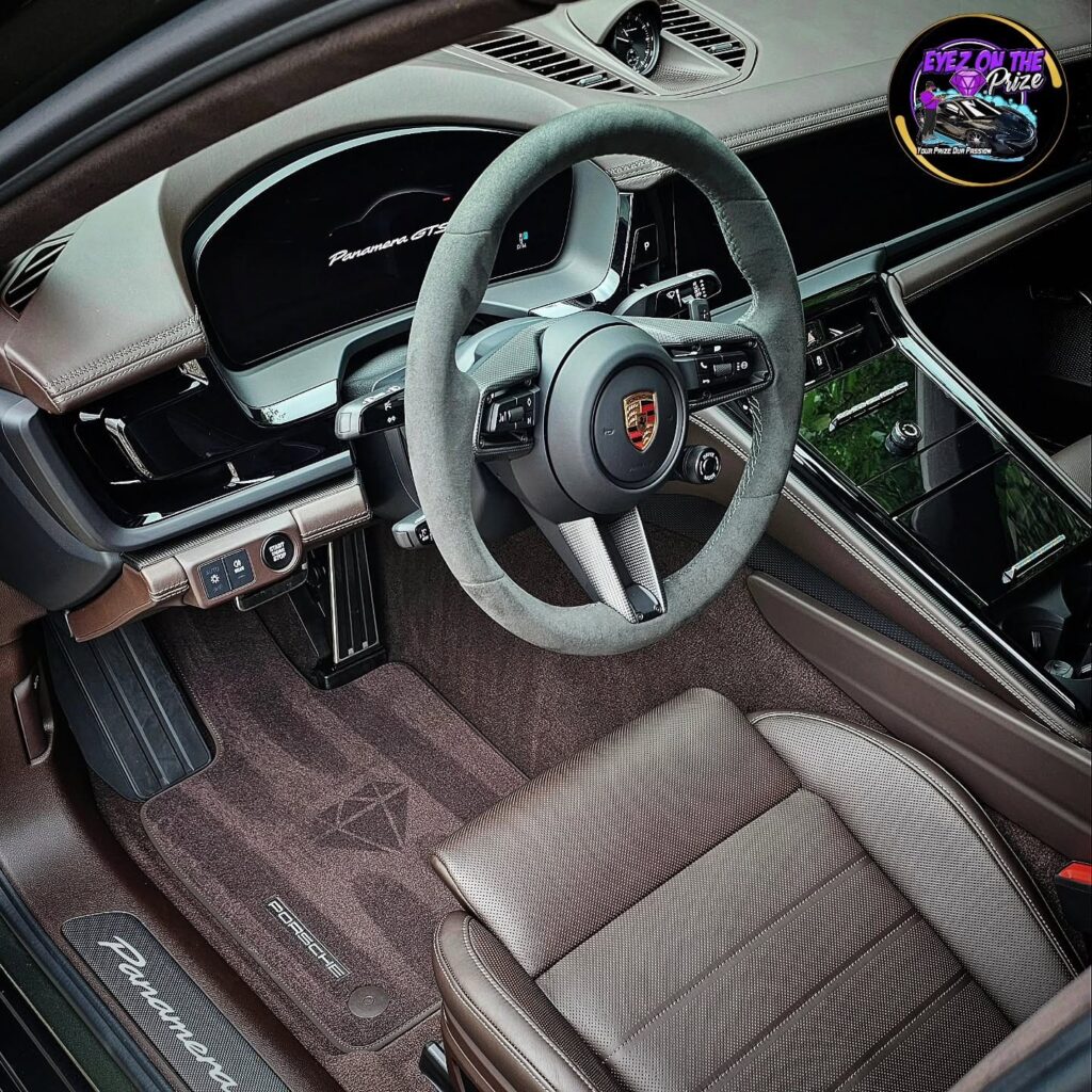 Porsche Panamera GTS driver cockpit with brown leather seat, Alcantara steering wheel, and freshly cleaned carpet.