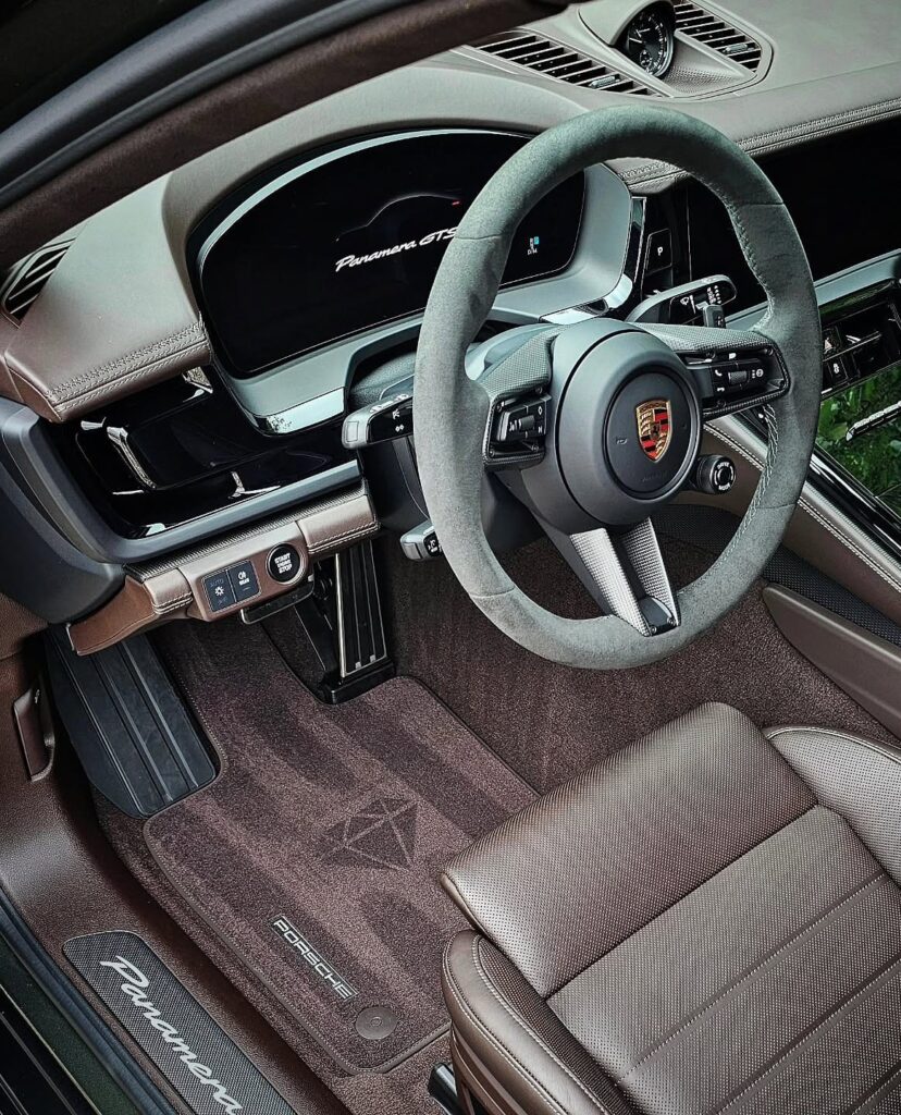Porsche Panamera GTS driver cockpit with brown leather seat, Alcantara steering wheel, and freshly cleaned carpet.