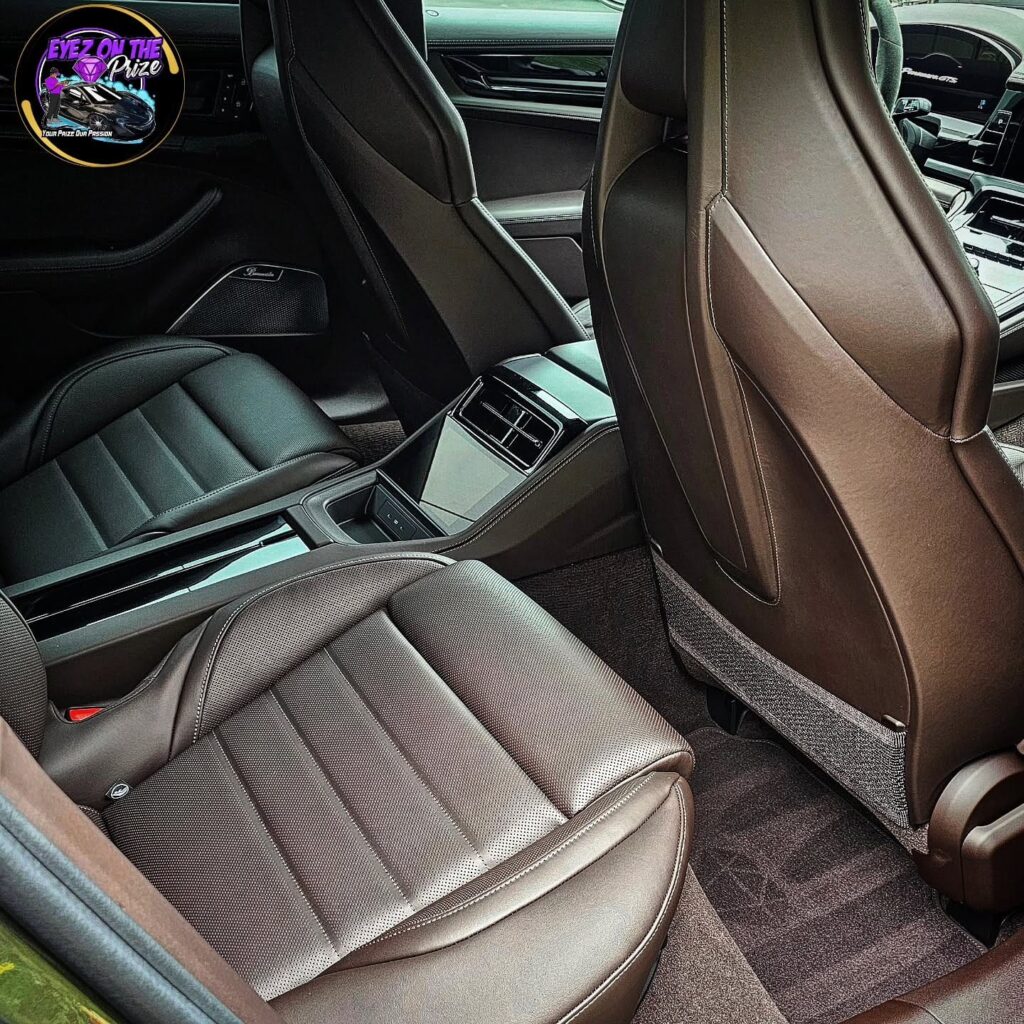 Rear seat view of a Porsche Panamera GTS with cleaned brown leather seats, carpet, and center console
