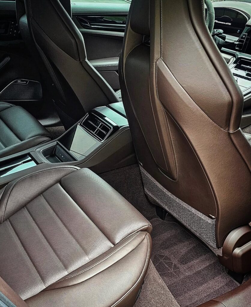 Rear seat view of a Porsche Panamera GTS with cleaned brown leather seats, carpet, and center console