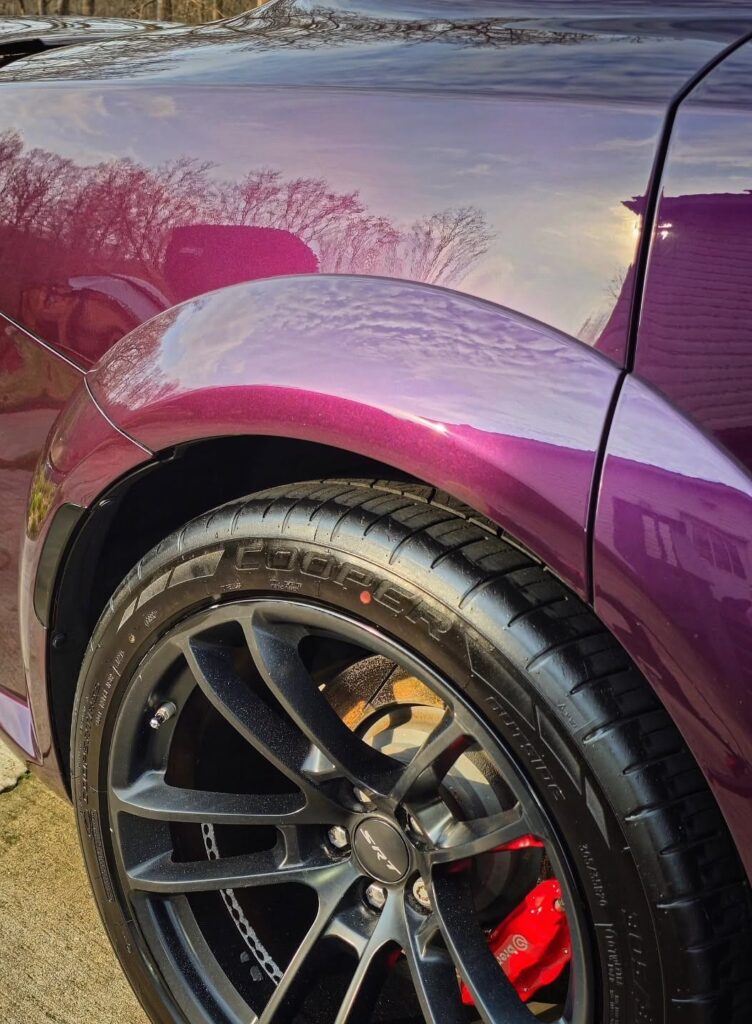 Close-up of a purple Dodge Charger widebody rear fender and SRT wheel with red Brembo caliper after detailing in Charlotte,