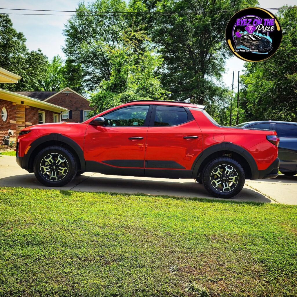 Red Hyundai Santa Cruz pickup shown in full side profile on a residential driveway after detailing
