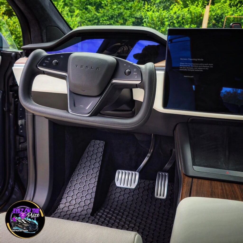 Tesla Model X yoke steering wheel, driver footwell, honeycomb floor mats, and touchscreen after interior detailing