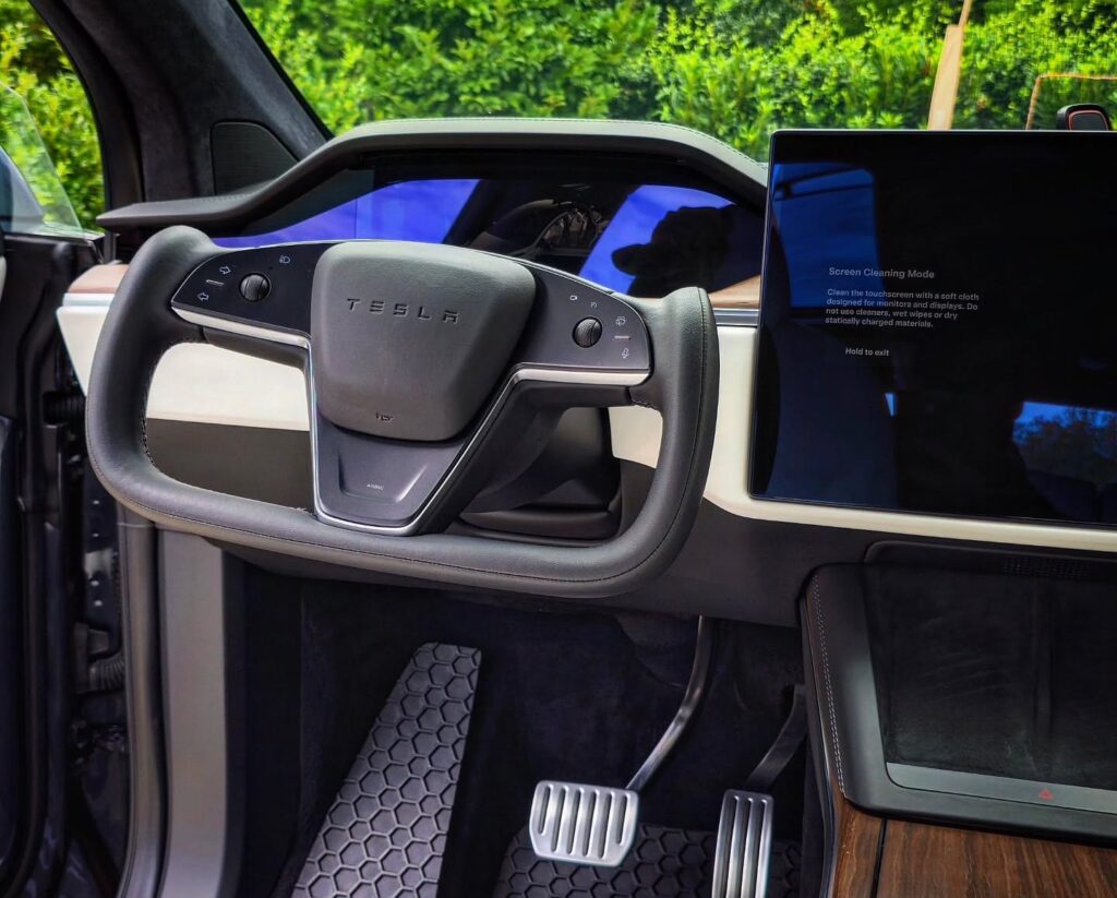 Tesla Model X yoke steering wheel, driver footwell, honeycomb floor mats, and touchscreen after interior detailing