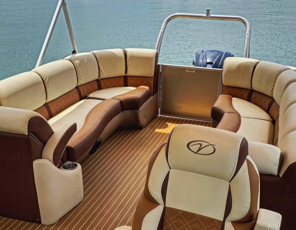 Cleaned tan and cream upholstery on a Veranda pontoon boat, showing the captain's chair, wraparound seating, and teak-style