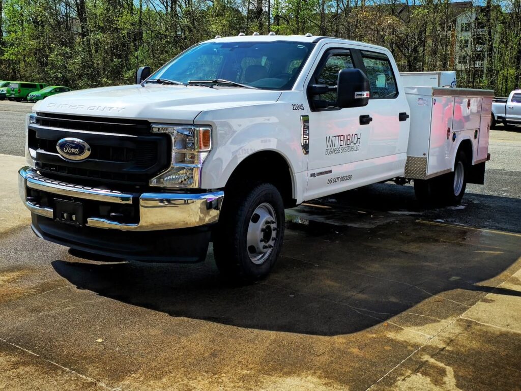 White Ford F-350 Super Duty crew cab with utility service body parked outdoors after exterior detailing in Charlotte, NC.
