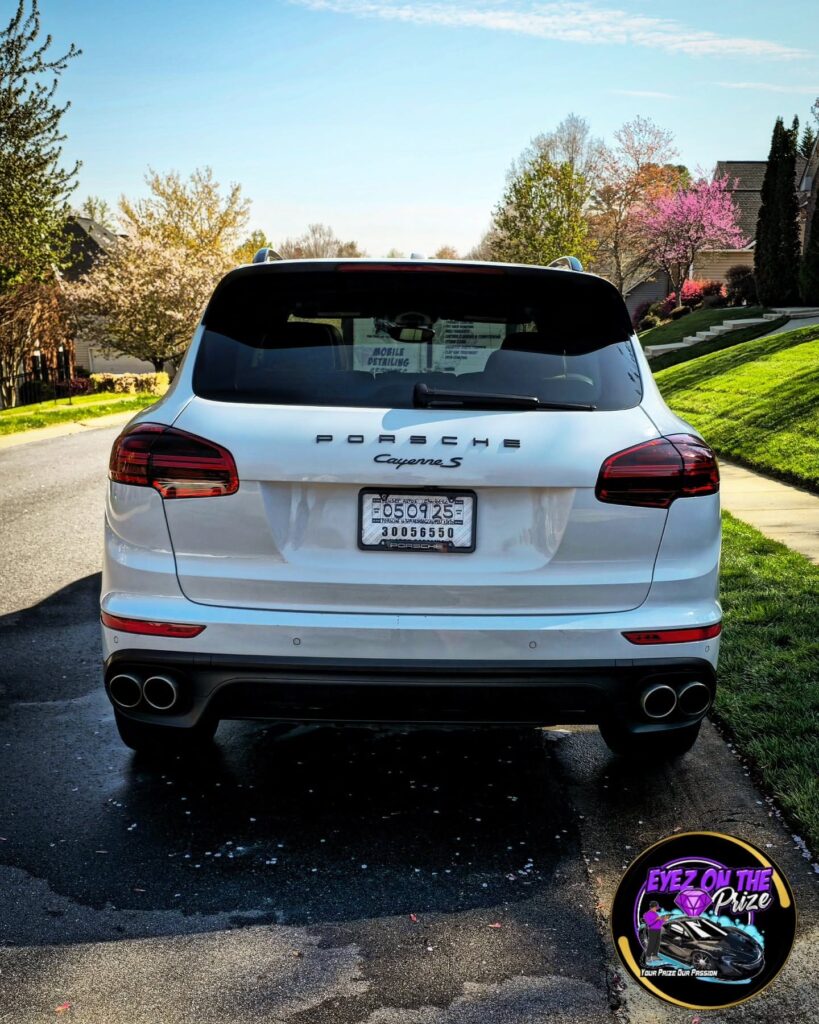 Rear view of a white Porsche Cayenne S parked on a residential street after detailing in Charlotte, NC.